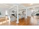 Open-concept living room with hardwood floors, fireplace, and elegant columns, ideal for entertaining at 303 Laurel Hill Road, Chapel Hill, NC 27514