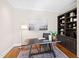Office with wood floors, built-in bookshelves, and a large painting at 303 Laurel Hill Road, Chapel Hill, NC 27514