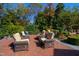 Cozy outdoor seating area with comfortable chairs, brick patio, and lush greenery for relaxation and entertaining at 303 Laurel Hill Road, Chapel Hill, NC 27514