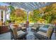 Inviting poolside patio has comfortable seating, and a pergola overlooking the pool and lush landscaping at 303 Laurel Hill Road, Chapel Hill, NC 27514