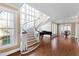 Elegant foyer features a grand curved staircase, hardwood floors, and large picture window allowing natural light at 303 Laurel Hill Road, Chapel Hill, NC 27514