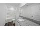 Bright bathroom featuring a granite vanity top, large mirror, and a shower-tub combo at 3517 Strawberry Patch Row, Raleigh, NC 27604