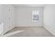 Bright bedroom with neutral carpet, a window with natural light, and a white door at 3517 Strawberry Patch Row, Raleigh, NC 27604