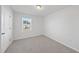 Bedroom featuring neutral carpet, a window providing natural light, and a white door at 3517 Strawberry Patch Row, Raleigh, NC 27604