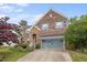 Charming brick home featuring a two-car garage, stone accents, and lush landscaping at 3614 Kilgo Dr, Durham, NC 27705