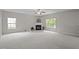 Bright living room featuring a fireplace, large windows, and an open floorplan with carpet flooring at 3614 Kilgo Dr, Durham, NC 27705