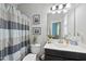 Well-lit bathroom featuring striped shower curtain, vanity, and framed artwork at 3621 Colby Chase Dr, Apex, NC 27539
