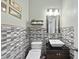 Stylish powder room showcasing mosaic tile walls, vessel sink, and modern lighting at 3621 Colby Chase Dr, Apex, NC 27539