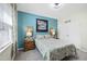 Cozy bedroom with blue accent wall, carpet, window with blinds, and wooden furniture at 3621 Colby Chase Dr, Apex, NC 27539