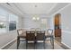 Elegant dining room featuring tray ceilings, a modern chandelier, and ample natural light from the windows at 3621 Colby Chase Dr, Apex, NC 27539