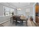 Elegant dining room featuring tray ceilings, a modern chandelier, and ample natural light from the windows at 3621 Colby Chase Dr, Apex, NC 27539