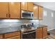 Modern kitchen featuring stainless steel oven, granite countertops, and wooden cabinets at 3621 Colby Chase Dr, Apex, NC 27539