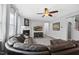 Inviting living room featuring a fireplace, large sectional sofa, ceiling fan, and wood floors at 3621 Colby Chase Dr, Apex, NC 27539