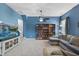 The living room features blue walls, a large tv and shelving along with comfortable, sectional seating at 3621 Colby Chase Dr, Apex, NC 27539
