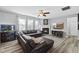 Comfortable living room features a fireplace, a large leather sectional, and a ceiling fan at 3621 Colby Chase Dr, Apex, NC 27539