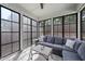 Sunroom features floor-to-ceiling windows, comfortable sectional sofa, and bright neutral colors at 3621 Colby Chase Dr, Apex, NC 27539