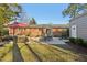 View of the backyard patio featuring dining and lounge seating next to well-maintained brick home at 3719 Hermine St, Durham, NC 27705