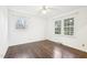 Bright bedroom featuring hardwood floors, two windows, and ceiling fan at 3719 Hermine St, Durham, NC 27705