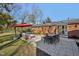 Inviting backyard with a spacious patio, outdoor furniture, and a charming red brick home at 3719 Hermine St, Durham, NC 27705
