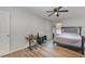 Bedroom with wood floors, neutral walls, ceiling fan, desk and chair, and a bed with a gray comforter at 38 Colonial Hills Dr, Lillington, NC 27546