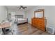 Cozy bedroom featuring wood floors, a ceiling fan, dresser with a mirror, and desk for a workspace at 38 Colonial Hills Dr, Lillington, NC 27546