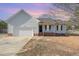 Charming single-story home with attached garage and inviting front porch, set against a colorful sunset at 38 Colonial Hills Dr, Lillington, NC 27546