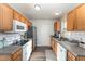 Traditional kitchen with wood cabinets, white appliances, stainless steel refrigerator and gray countertops at 38 Colonial Hills Dr, Lillington, NC 27546
