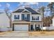 Charming two-story home with a two-car garage, a stone accent wall, and a well-manicured front lawn at 3800 Cross Timber Ln, Raleigh, NC 27603