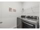 Modern laundry room featuring stainless steel washer and dryer and shelving unit above at 3800 Cross Timber Ln, Raleigh, NC 27603