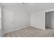 A carpeted bedroom featuring a vaulted ceiling and a door to the hallway at 3811 Chehaw Dr, Raleigh, NC 27610