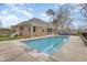 A beautiful backyard pool area with a brick home and screened porch at 4 Tocuvan Pl, Durham, NC 27705