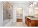 Bright bathroom offers tiled shower and tub combination, granite vanity and tile floors at 4 Tocuvan Pl, Durham, NC 27705