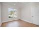 Bright bedroom offers hardwood floors and a large window providing ample natural light and views of the yard at 4 Tocuvan Pl, Durham, NC 27705