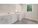 Bright laundry room features washer, dryer, built-in cabinets, utility sink, and tiled floors at 4 Tocuvan Pl, Durham, NC 27705