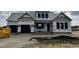 New construction home featuring a covered entry and garage, awaiting finishing touches in a developing community at 414 Springtooth Dr, Zebulon, NC 27597