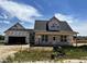 New home under construction featuring a modern design, two-car garage, and covered front porch at 432 Springtooth Dr, Zebulon, NC 27597
