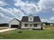 Charming exterior view of a white home with a manicured lawn and a detached garage at 432 Springtooth Dr, Zebulon, NC 27597