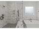 Walk-in glass shower with marble tile surround and a soaking tub with black fixtures at 4508 Chandler Creek Pl, Apex, NC 27539