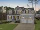 Charming two-story home featuring a manicured lawn, gray siding, dormer windows and a two car garage at 4508 Chandler Creek Pl, Apex, NC 27539