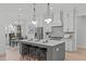 Bright, open kitchen with stainless steel appliances, a large island with seating, and modern pendant lighting at 4508 Chandler Creek Pl, Apex, NC 27539