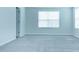 Well-lit bedroom with neutral gray walls, carpeted floors, and two windows with blinds at 4914 Arkose Dr, Raleigh, NC 27610