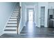 Inviting entryway featuring staircase, wood-look floors, and access to pantry and stainless steel refrigerator at 4914 Arkose Dr, Raleigh, NC 27610