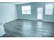 Bright living room with wood-look floors, two windows, and a glass door to the exterior at 4914 Arkose Dr, Raleigh, NC 27610