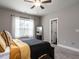 Well-lit bedroom with carpet flooring, neutral walls, and large window with sheer curtains at 5 Morning Dove Ct, Clayton, NC 27520