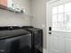 Functional laundry room with modern black washer and dryer and shelving for storage at 5 Morning Dove Ct, Clayton, NC 27520