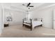 Neutral bedroom featuring a ceiling fan, large bed, carpet and dual windows for ample light at 5112 Lizard Tail Ln, Raleigh, NC 27603
