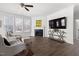 Bright living room with hardwood floors, fireplace, and ample natural light from large windows at 5112 Lizard Tail Ln, Raleigh, NC 27603