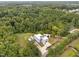 Aerial view of a modern home on a large lot surrounded by trees, a lush lawn, and long paved driveway at 5217 Tanglewild Dr, Raleigh, NC 27613