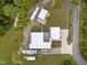 Aerial view of a modern home featuring a light-colored roof, long driveway, lush landscaping, and plenty of parking at 5217 Tanglewild Dr, Raleigh, NC 27613