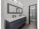 Elegant bathroom with double vanity, large mirror, modern lighting, and glass enclosed shower at 5217 Tanglewild Dr, Raleigh, NC 27613